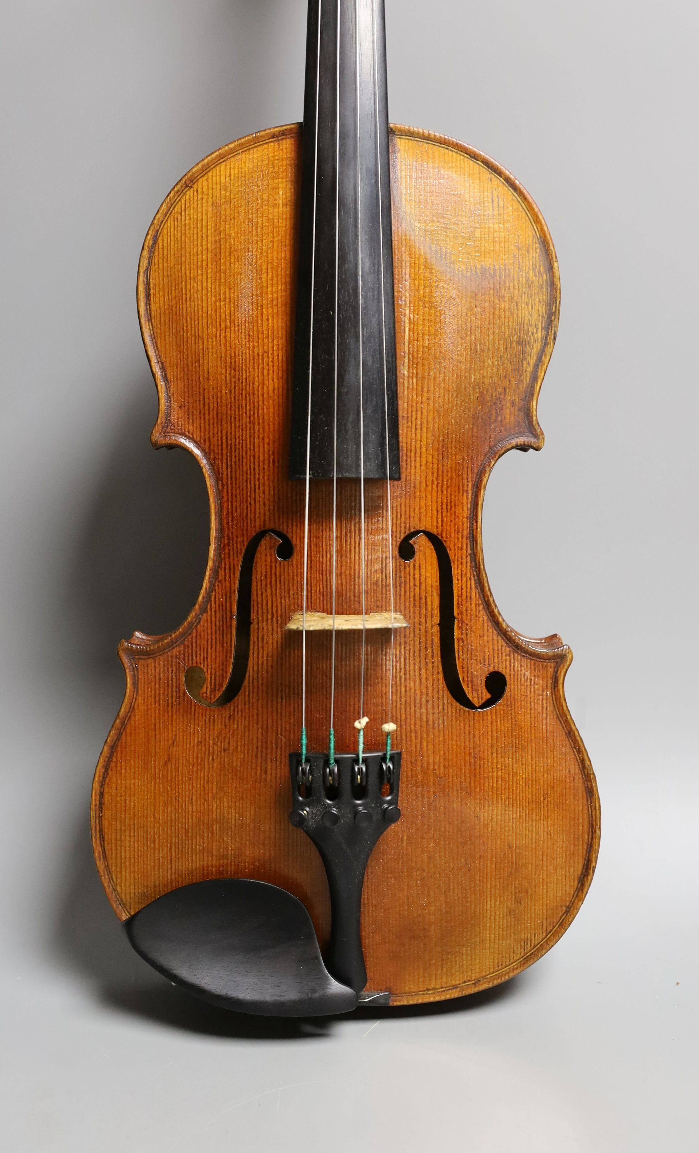 A 19th century violin labelled JB Guadagnini, back measures 35cm, with two bows, one silver-mounted.
